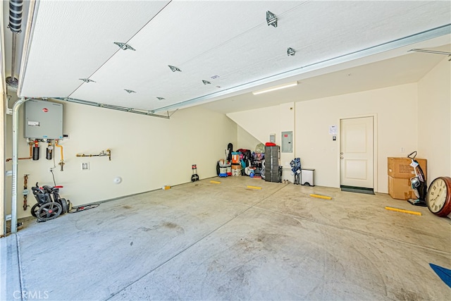 garage featuring electric panel and water heater