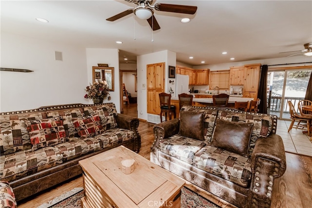 living room with ceiling fan and light hardwood / wood-style flooring