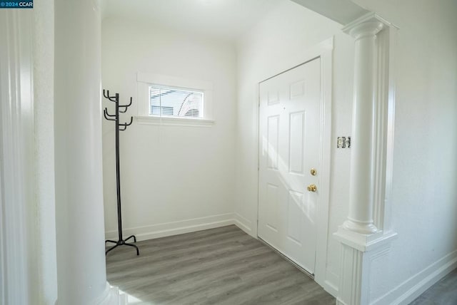 doorway to outside with wood-type flooring and decorative columns