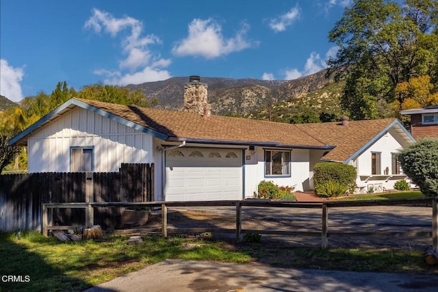 single story home featuring a mountain view and a garage