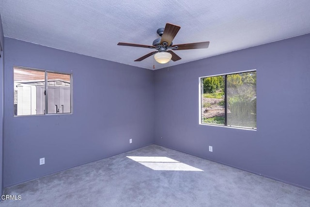 unfurnished room with ceiling fan, carpet floors, and a textured ceiling