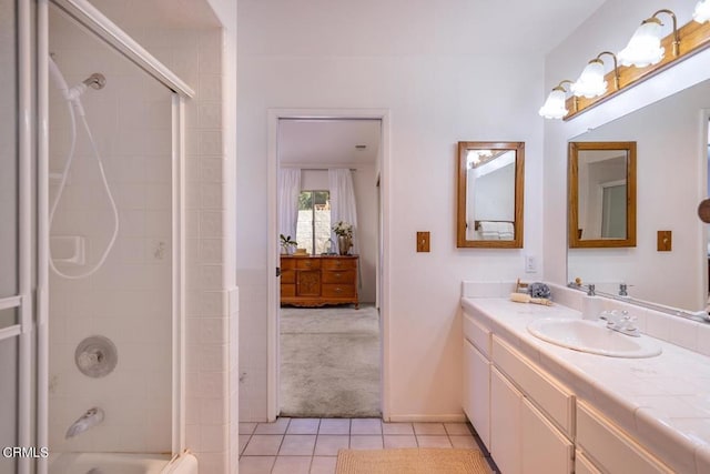 bathroom featuring tile patterned flooring, vanity, and tiled shower / bath