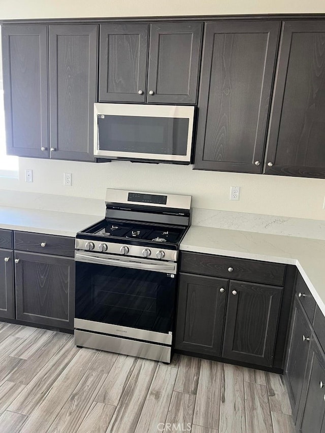 kitchen with stainless steel appliances and light hardwood / wood-style floors