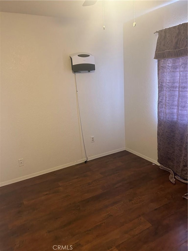 empty room with dark hardwood / wood-style floors and ceiling fan