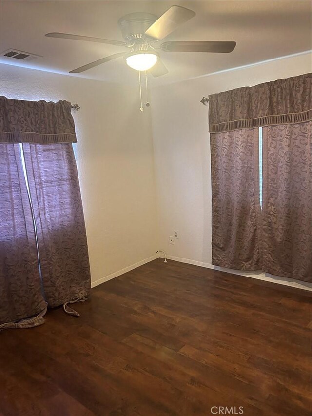 unfurnished room featuring ceiling fan and dark hardwood / wood-style flooring