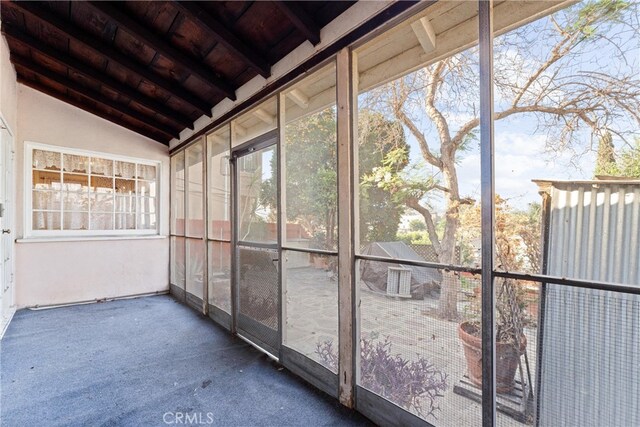 unfurnished sunroom featuring lofted ceiling and plenty of natural light