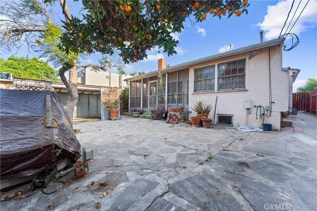 rear view of property with a patio and a sunroom