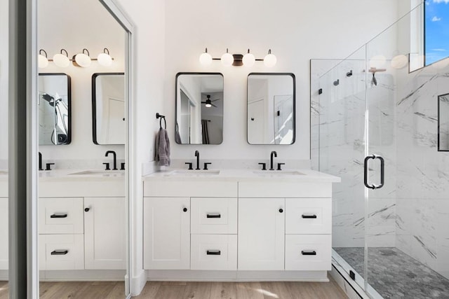 bathroom with hardwood / wood-style floors, vanity, and a shower with door