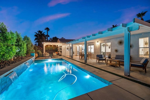 pool at dusk with a pergola, a patio area, pool water feature, and an outdoor hangout area