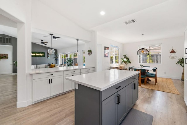 kitchen featuring pendant lighting, light hardwood / wood-style flooring, vaulted ceiling, and ceiling fan