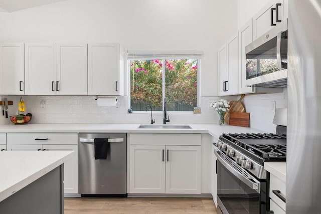 kitchen featuring light hardwood / wood-style floors, sink, white cabinetry, and stainless steel appliances