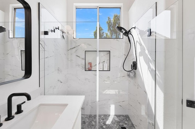 bathroom featuring vanity, a shower with door, and a healthy amount of sunlight