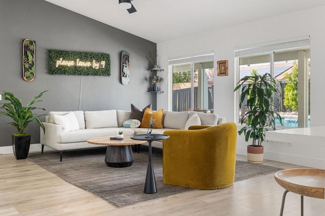 living room featuring lofted ceiling, ceiling fan, and wood-type flooring