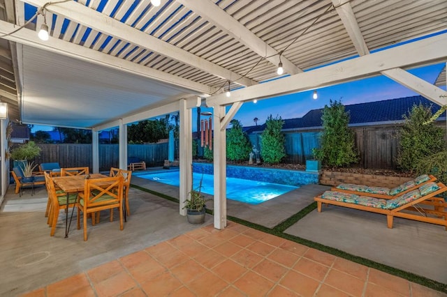 pool at dusk featuring a patio