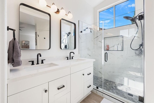 bathroom with wood-type flooring, vanity, and an enclosed shower