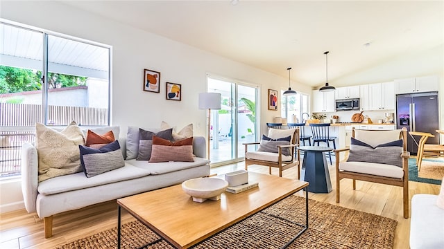 living room featuring light wood-type flooring and lofted ceiling