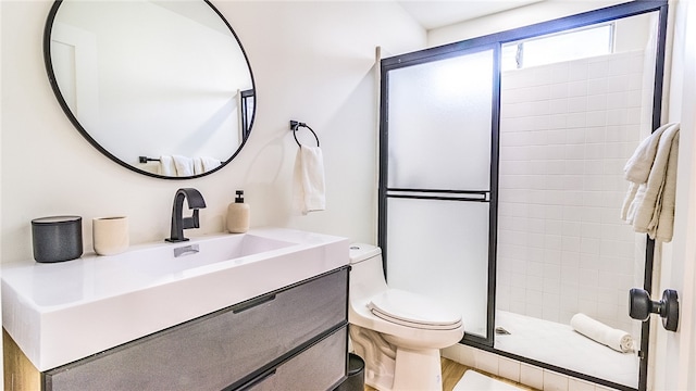 bathroom featuring vanity, toilet, and a shower with shower door