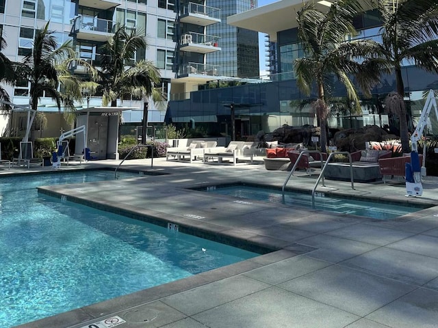 view of swimming pool with a hot tub and a patio