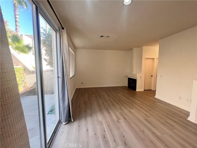 unfurnished living room with hardwood / wood-style flooring and a large fireplace