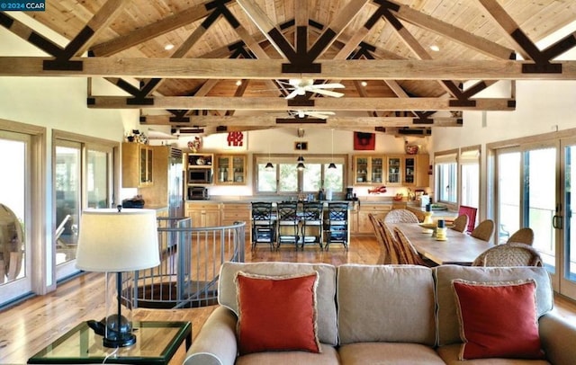 living room with high vaulted ceiling, wooden ceiling, light wood-type flooring, and beam ceiling