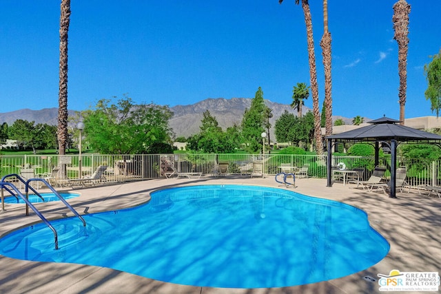 view of swimming pool with a gazebo, a mountain view, and a patio