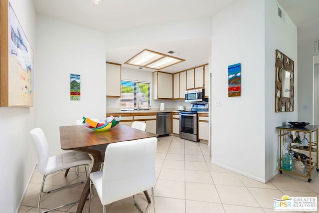 kitchen with sink, stainless steel appliances, and light tile patterned floors