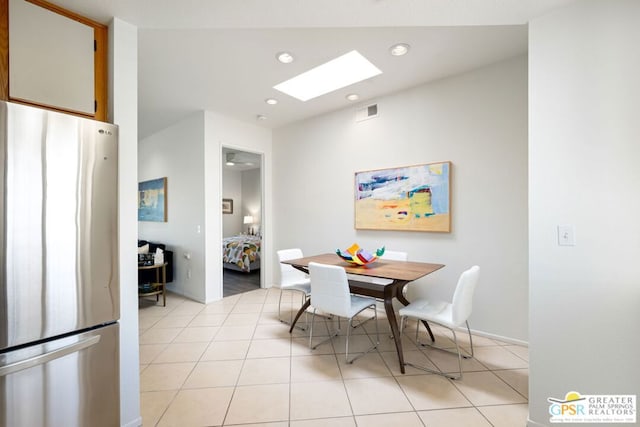 dining area with light tile patterned flooring and a skylight