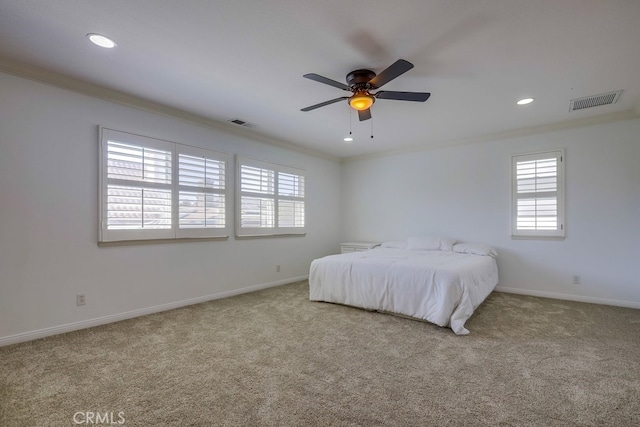 carpeted bedroom with ornamental molding and ceiling fan