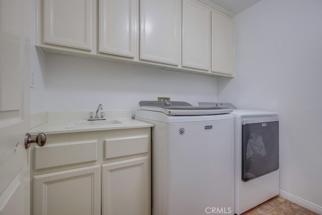 clothes washing area with washer and dryer, sink, cabinets, and light tile patterned flooring