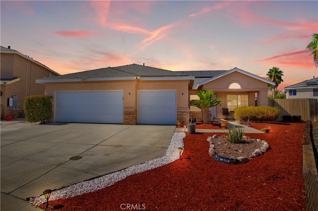 view of front of property with a garage and solar panels