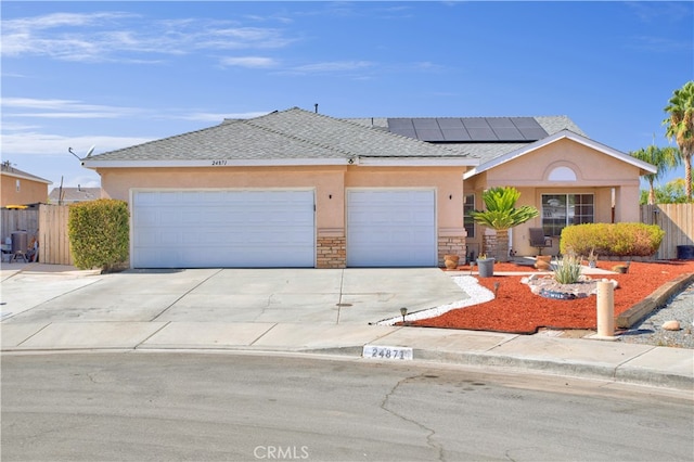 single story home with a garage and solar panels