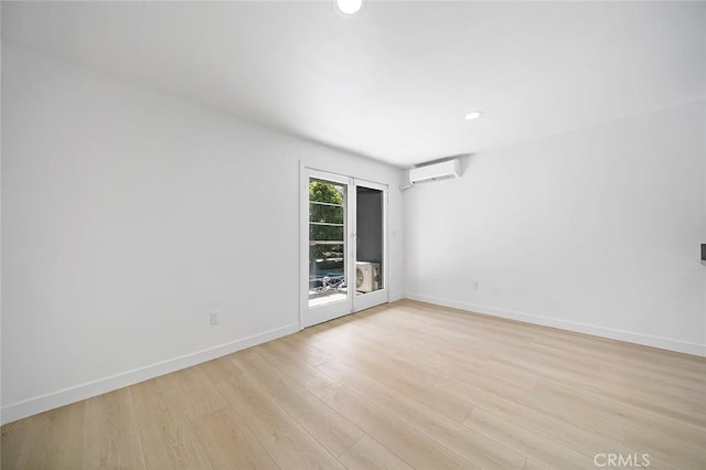 empty room featuring light hardwood / wood-style flooring and a wall mounted AC