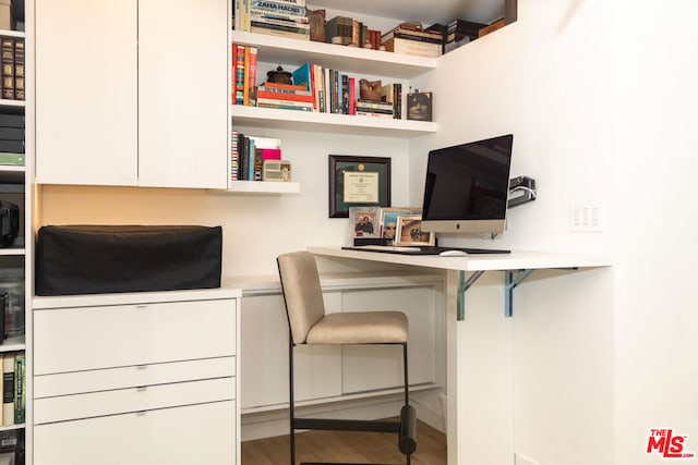 office with built in desk and hardwood / wood-style floors