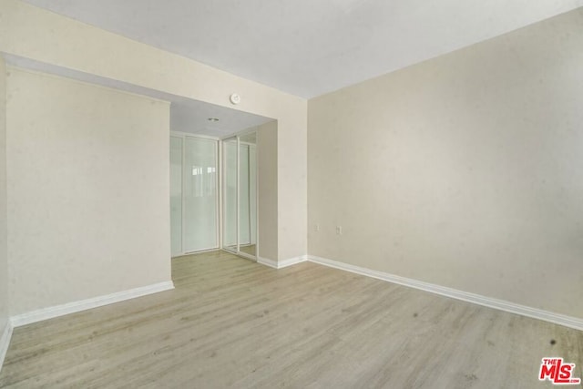 unfurnished room with light wood-type flooring