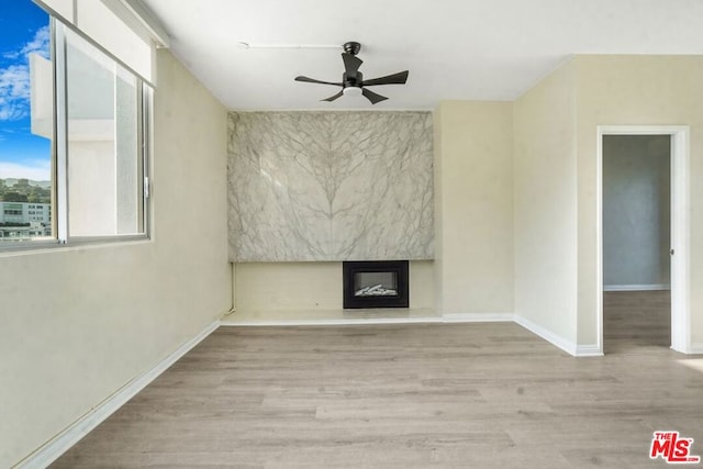 unfurnished living room with ceiling fan and light wood-type flooring