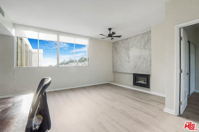 unfurnished office with ceiling fan and light wood-type flooring