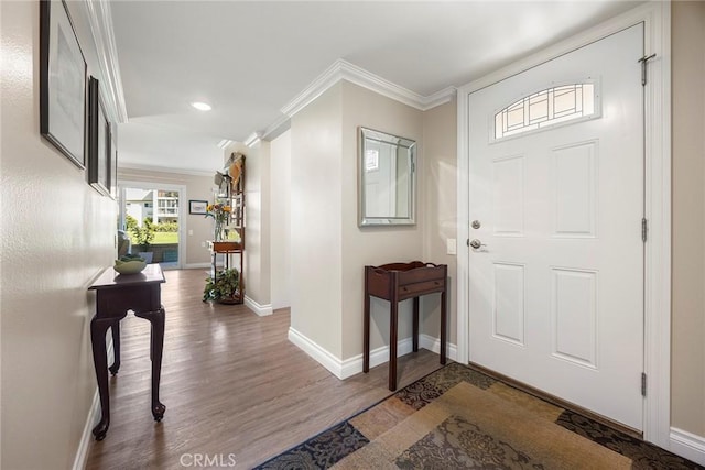 foyer entrance with crown molding, recessed lighting, wood finished floors, and baseboards