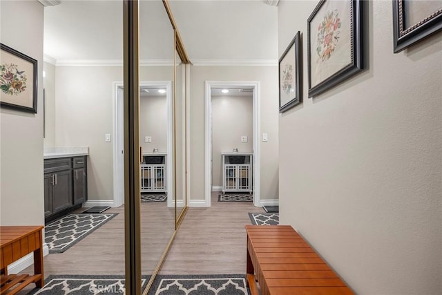 hall with wood finished floors, crown molding, and baseboards