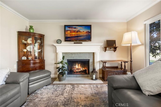sitting room featuring baseboards, wood finished floors, a fireplace, and crown molding