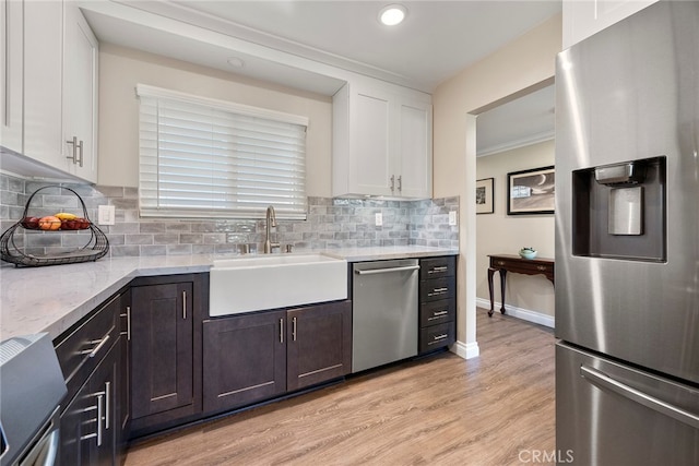 kitchen with stainless steel appliances, white cabinets, sink, light hardwood / wood-style floors, and dark brown cabinets