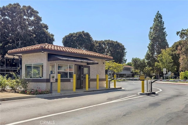 view of road with curbs, a gated entry, and traffic signs