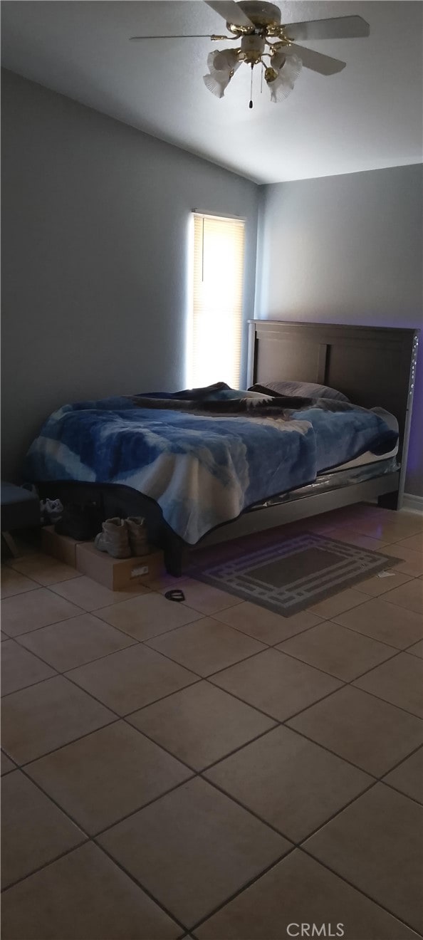 bedroom with ceiling fan and tile patterned flooring