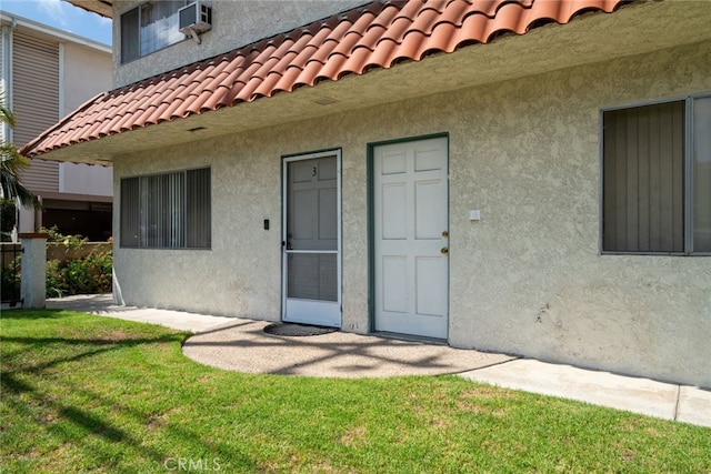 view of exterior entry with a yard