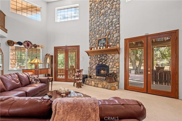 living room featuring plenty of natural light, light colored carpet, a high ceiling, and french doors