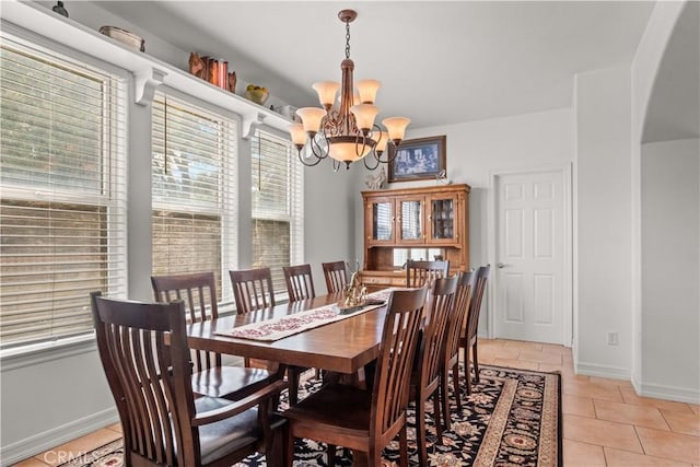 tiled dining room with a chandelier