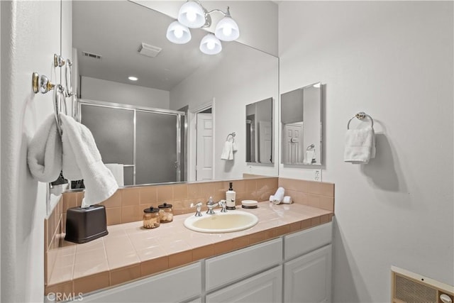 bathroom with decorative backsplash, vanity, and walk in shower