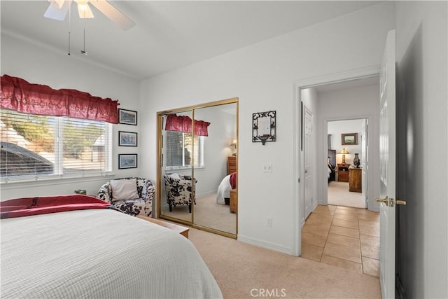 carpeted bedroom featuring ceiling fan and a closet