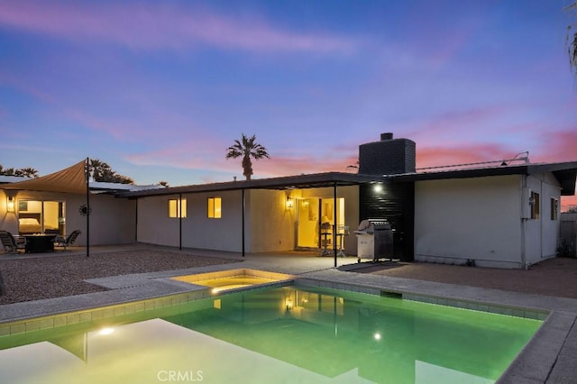 back house at dusk with a swimming pool with hot tub, cooling unit, and a patio area