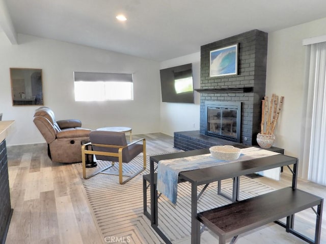 living room featuring light wood-style flooring, a fireplace, and recessed lighting