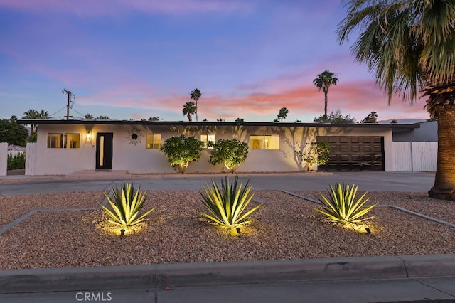 view of front of home featuring concrete driveway, an attached garage, and stucco siding